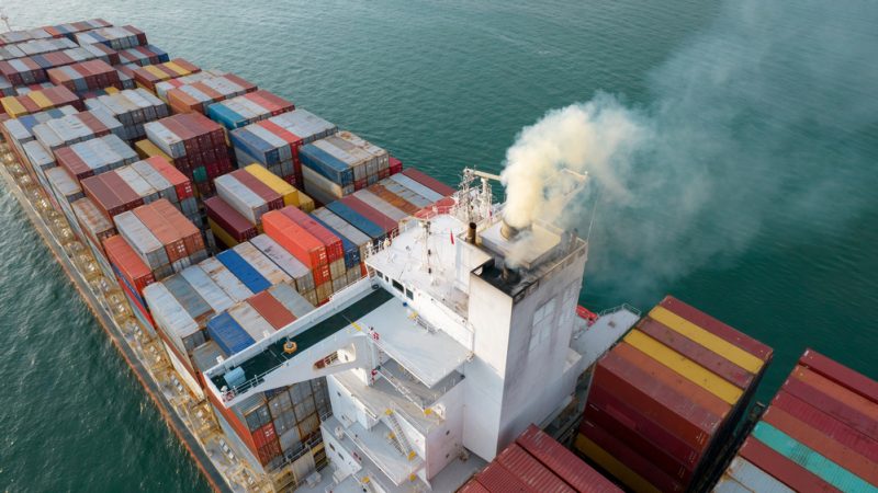 Containerschip met rookwolk