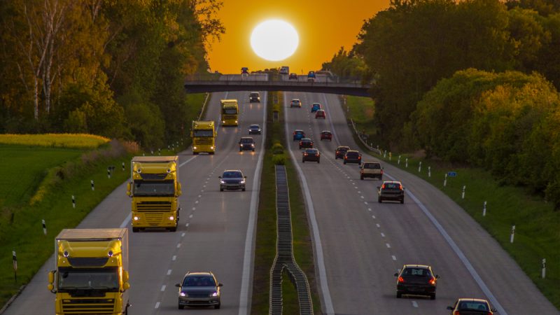 Vrachtwagens op de Duitse Autobahn bij zonsondergang